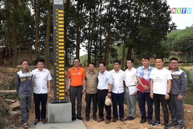 A group of men standing next to a tall meter

Description automatically generated